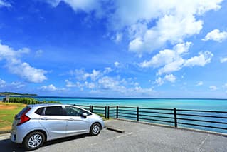 宮古島の駐車場に止まっている車と海