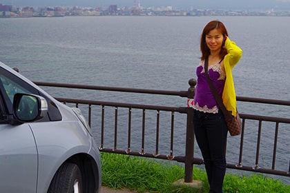 津軽海峡を背景に写真を撮る女性