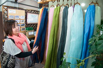 リネンのストールを選ぶ女性