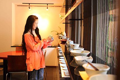 ギャラリーで食器を持つ女性